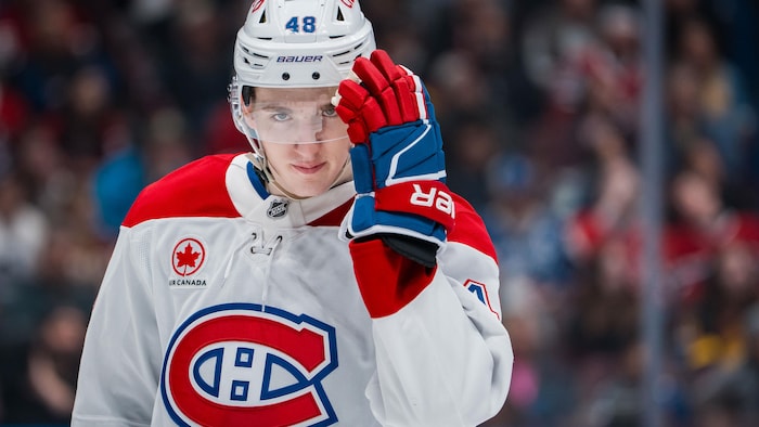 Il replace son casque protecteur lors d'un arrêt de jeu.