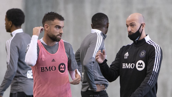 Un entraîneur donne des instructions à un joueur de soccer.