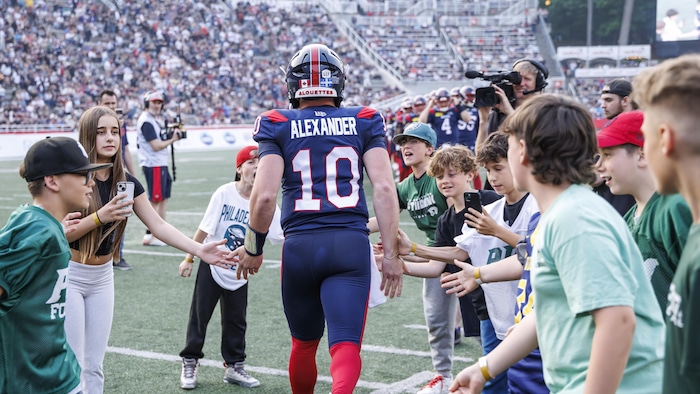 Davis Alexander tape dans la main de jeunes amateurs en se dirigeant vers le terrain.