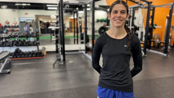 Une jeune athlète prend la airs determination la caméra dans un gymnase.
