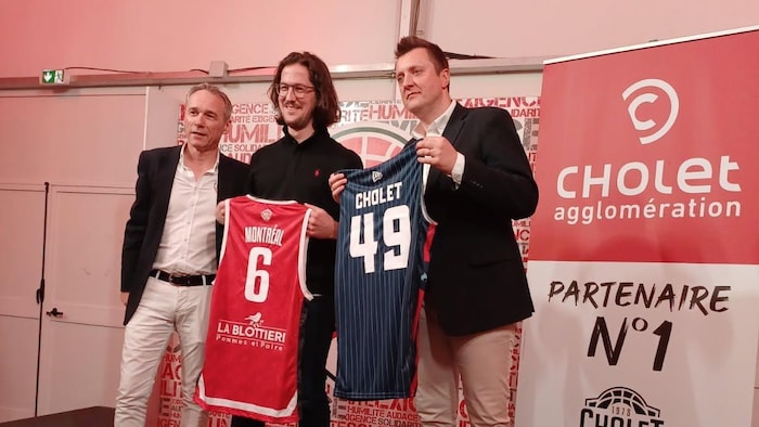 Deux hommes tiennent des maillots symboliques lors d’une présentation.