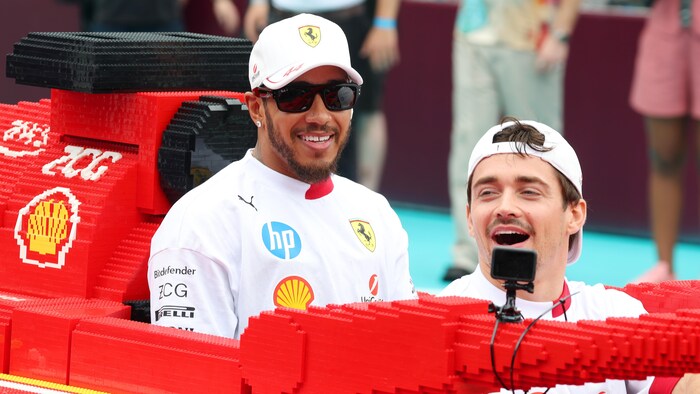 Lewis Hamilton et Charles Leclerc rigolent, à bord d'une réplique d'une F1 de Ferrari en lego, pendant un évènement promotionnel au Grand Prix de Miami. 