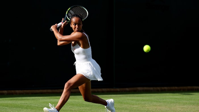 Une joueuse de tennis s'apprête à frapper une balle.