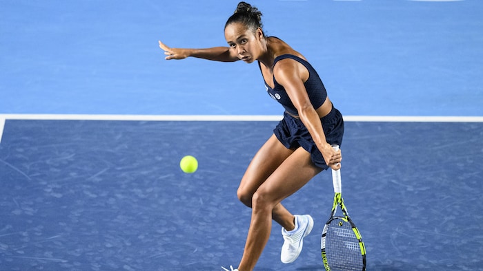 Elle regarde la balle qu'elle vient de frapper du revers.