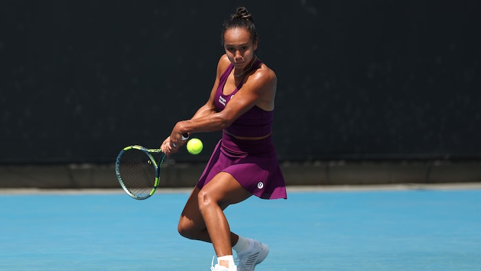 Une joueuse de tennis s'apprête à frapper la balle du revers.