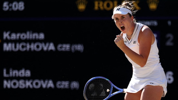Une joueuse de tennis crie et serre le poing.