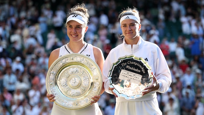 Deux joueuses sourient en regardant la caméra avec leurs trophées. 