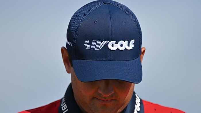 Un golfeur porte une casquette avec l'inscription LIV Golf.