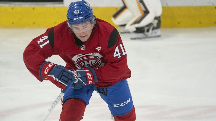 Un joueur de hockey en rouge patine à pleine vitesse.