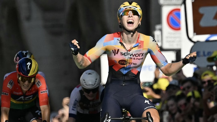 Une cycliste franchit une ligne d'arrivée.
