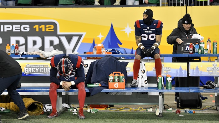 Deux joueurs de football sur le banc semblent très déçus.