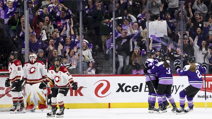 Quatre joueuses du Frost du Minnesota célèbrent près du but de la Charge d'Ottawa.