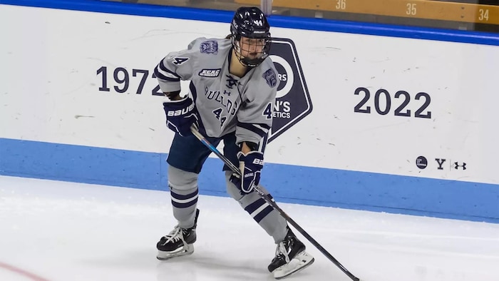 Une hockeyeuse est sur la glace.