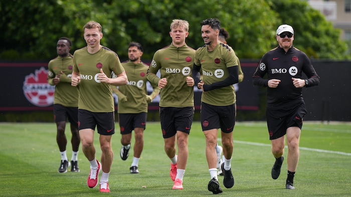 Des joueurs de soccer courent ensemble à l'entrainement.