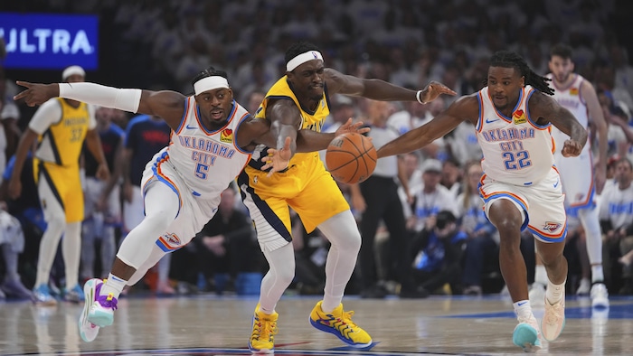 Un joueur en blanc ravit la ballon à un adversaire en jaune.