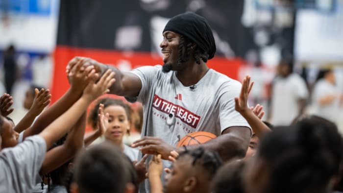 Un homme donne des tapes dans les mains d'enfants.