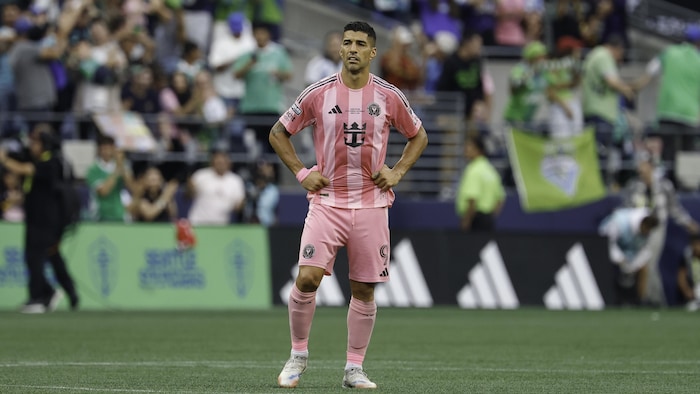 Un joueur de soccer attend sur le terrain.