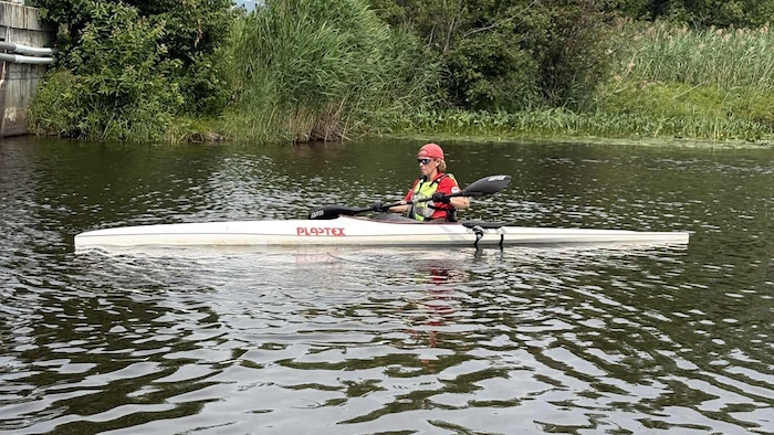 A woman paddling on a river.