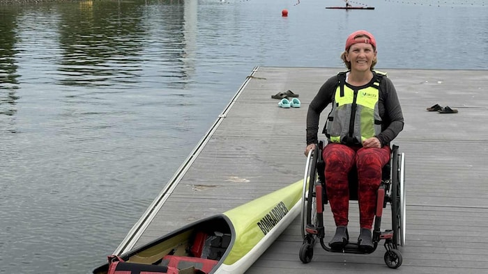 She smiles on a pontoon, next to a kayak.
