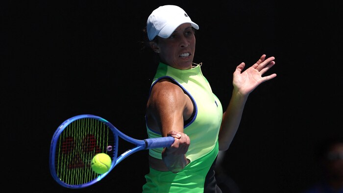 Une joueuse de tennis frappe un coup droit.
