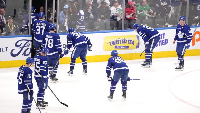 Les joueurs des Maple Leafs, déçus, quittent la patinoire après leur défaite.