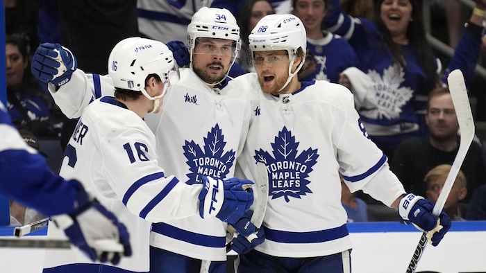 Auston Matthews, William Nylander et Mitch Marner célèbrent ensemble un but de leur équipe.