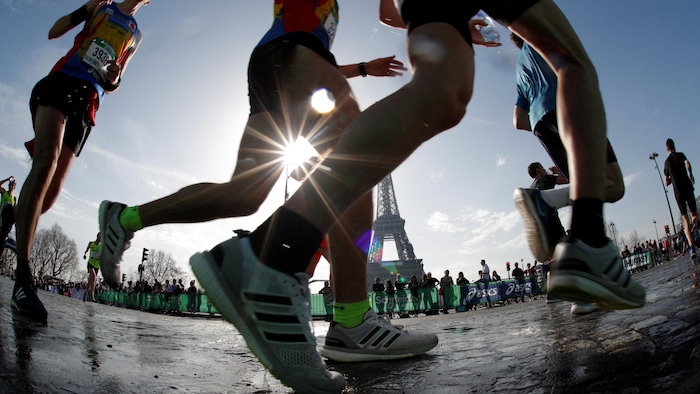Des coureurs s'élancent devant la tour Eiffel.