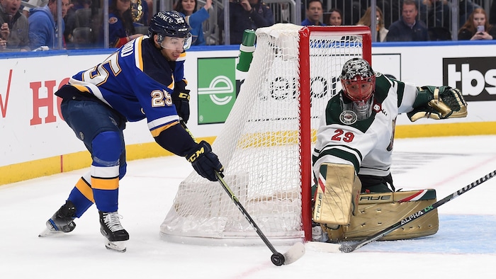 Un joueur de hockey tente de déjouer un gardien de but.