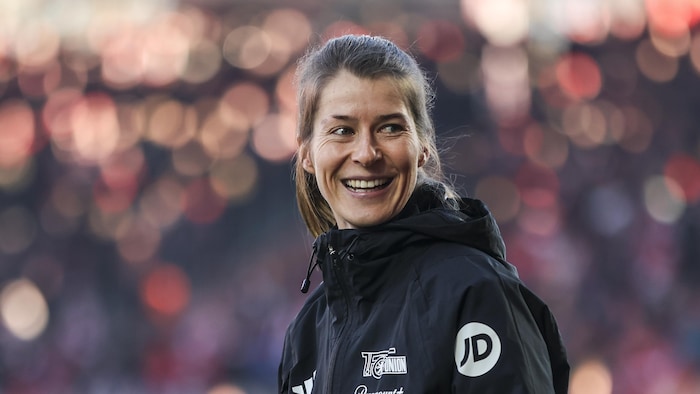Une entraineuse de soccer sourit.