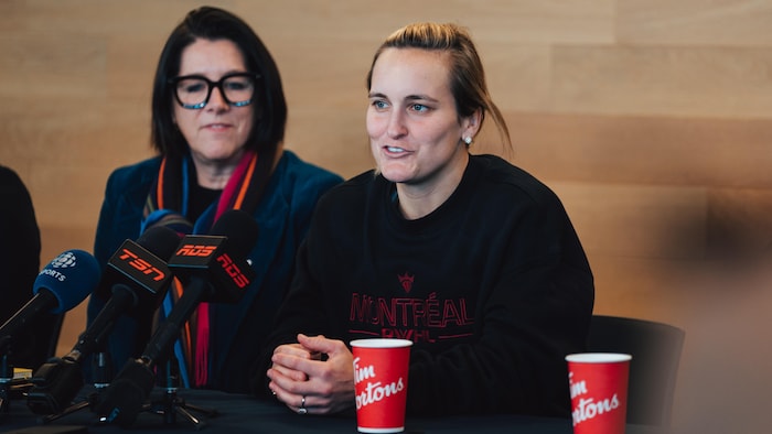 Deux femmes parlent dans un microphone lors d'une conférence de presse. 