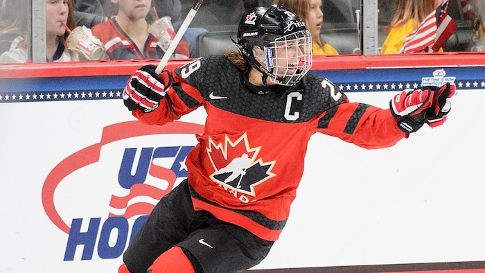 Une joueuse de hockey célèbre un but de son équipe.