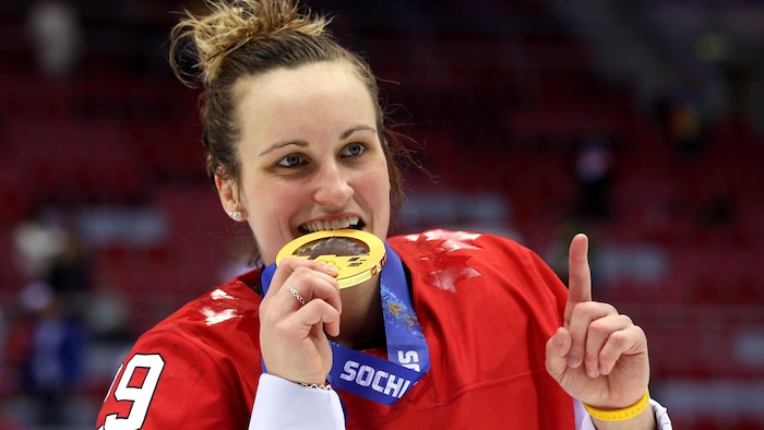 Une joueuse de hockey mord dans une médaille. 