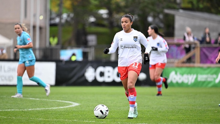 Une joueuse de soccer en contrôle du ballon.
