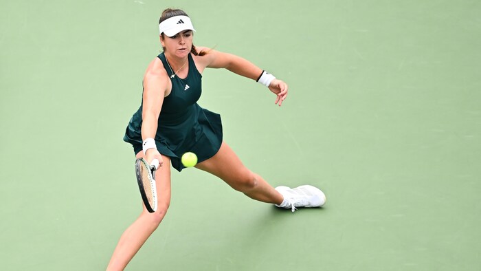 Une joueuse de tennis frappe un coup droit.