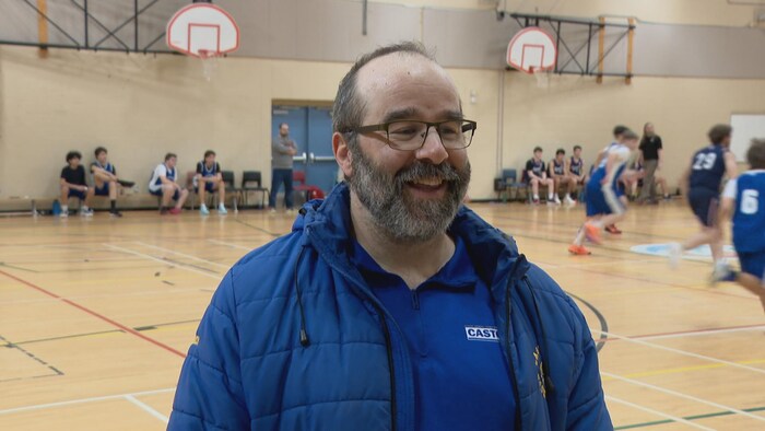 Bearded man smiling in front of the camera.