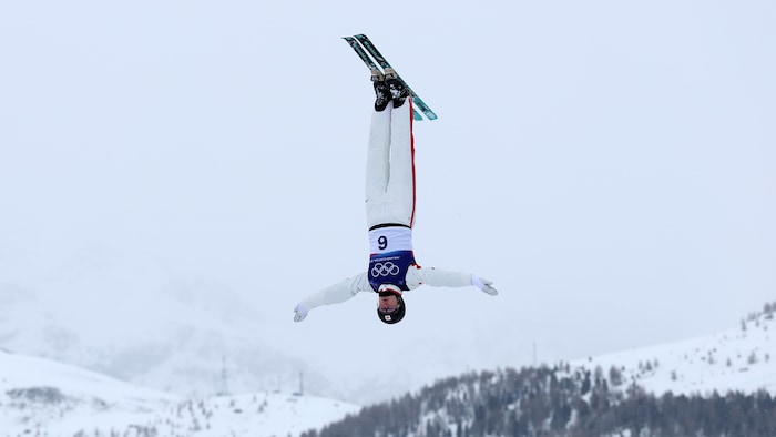 Elle est dans les airs avec la tête vers le bas.
