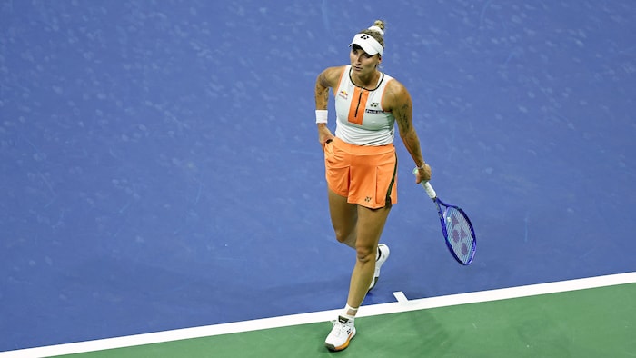 Une joueuse de tennis marche sur le terrain.