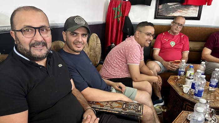 Des amis et partisans du Maroc posent fièrement dans un café à Montréal.