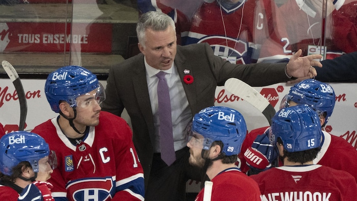 L'entraîneur donne des directives à ses joueurs au banc de l'équipe.