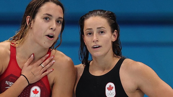 Les deux femmes, en combinaison de natation, discutent près de la piscine.  