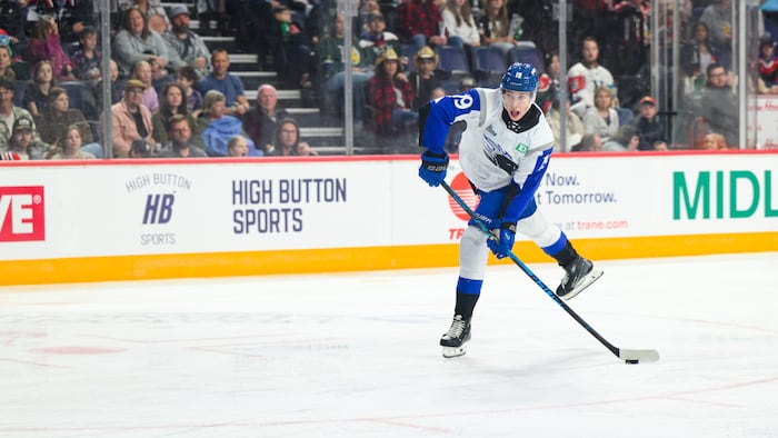 Un joueur de hockey prend un tir au but pendant un match junior.