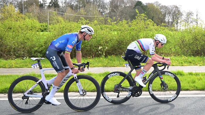 Deux cyclistes roulent dans la campagne.