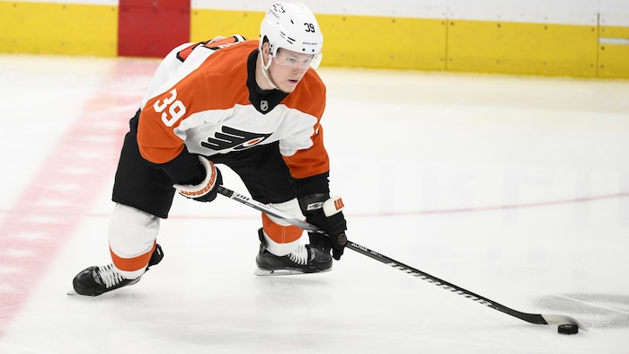 Un joueur de hockey manie une rondelle.