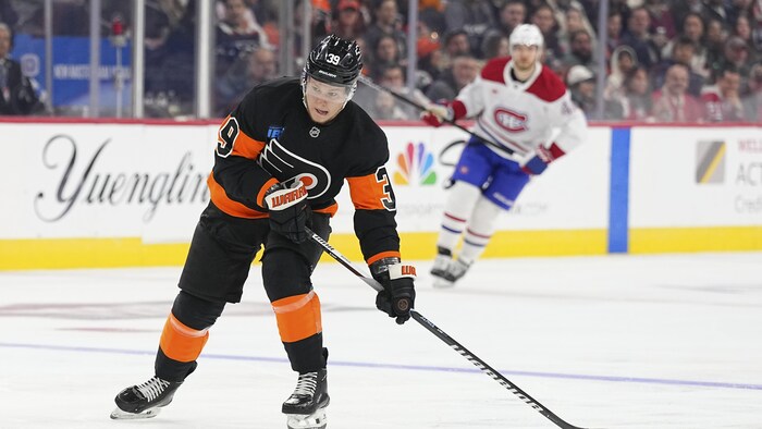 Un joueur de hockey s'apprête à décocher un tir. 