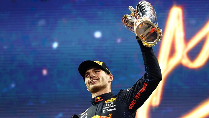 Un homme soulève un trophée.
