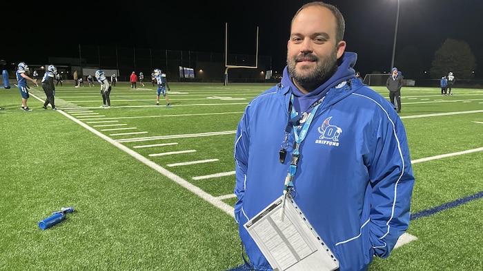 Football coach standing on the bench during training.