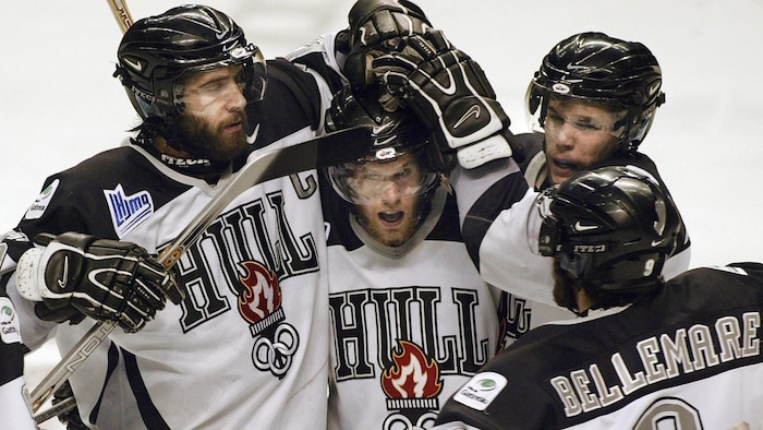 Des joueurs de hockey junior célèbrent un but pendant un tournoi. 