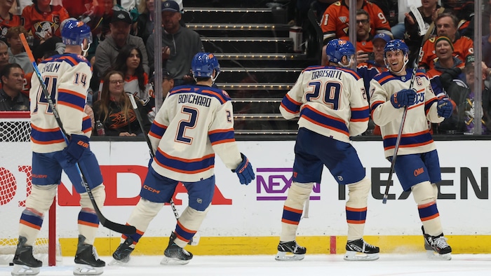 Mattias Ekholm, Evan Bouchard et Leon Draisaitl félicitent Connor McDavid après un but.