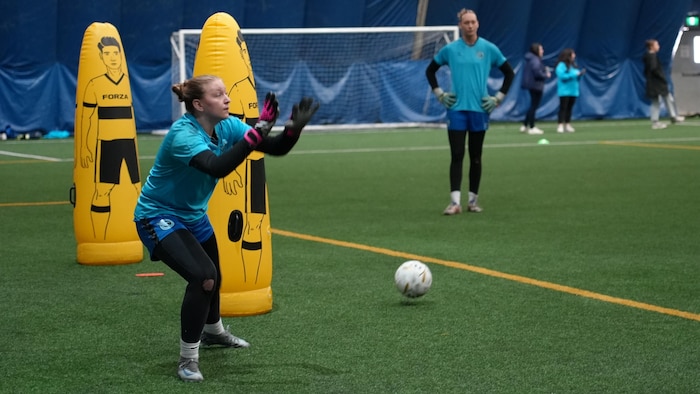 Une gardienne de soccer fait un arrêt pendant un entraînement,