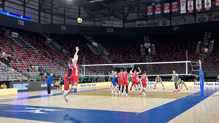 Joueur de volleyball qui s'élance pour frapper un ballon.